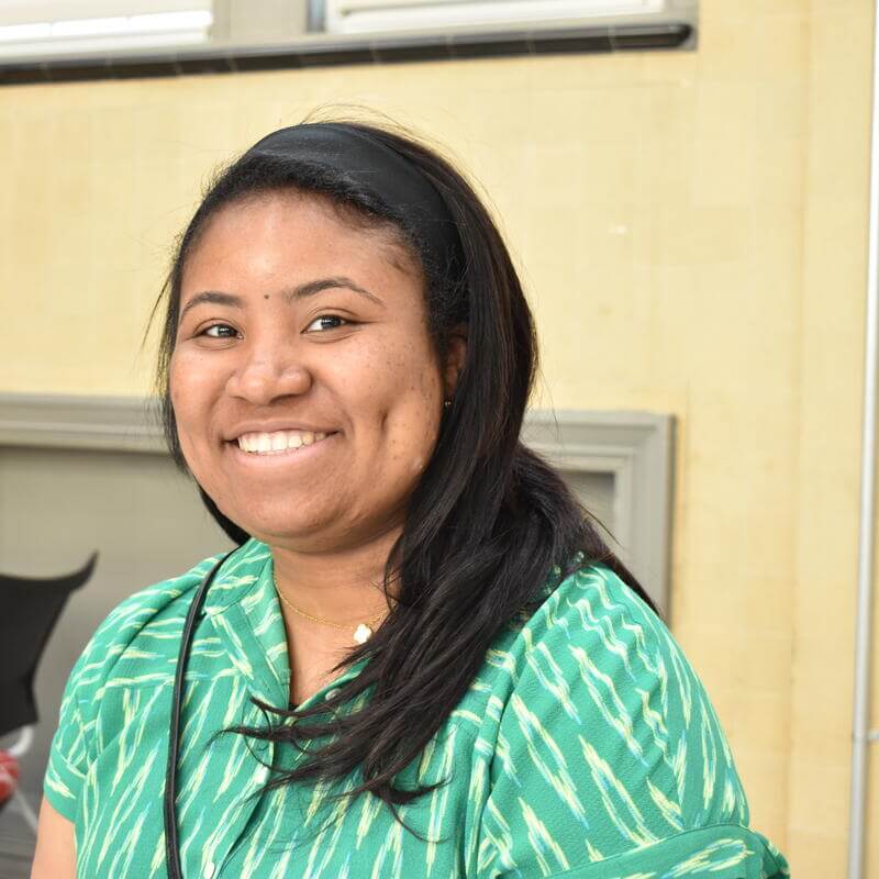 student smiling in a green shirt