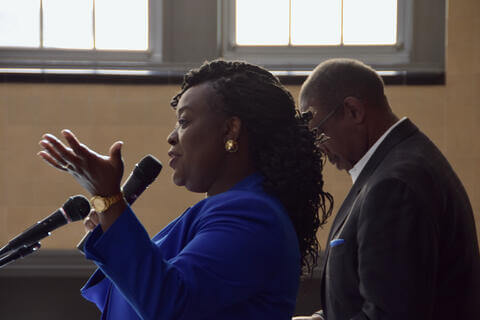 woman in blue jacket speaking on microphone