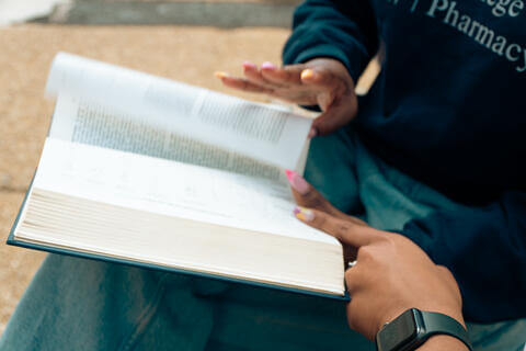 student holding opened book