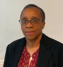 woman in red shirt and black jacket smiling