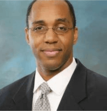 headshot of man in jacket and tie